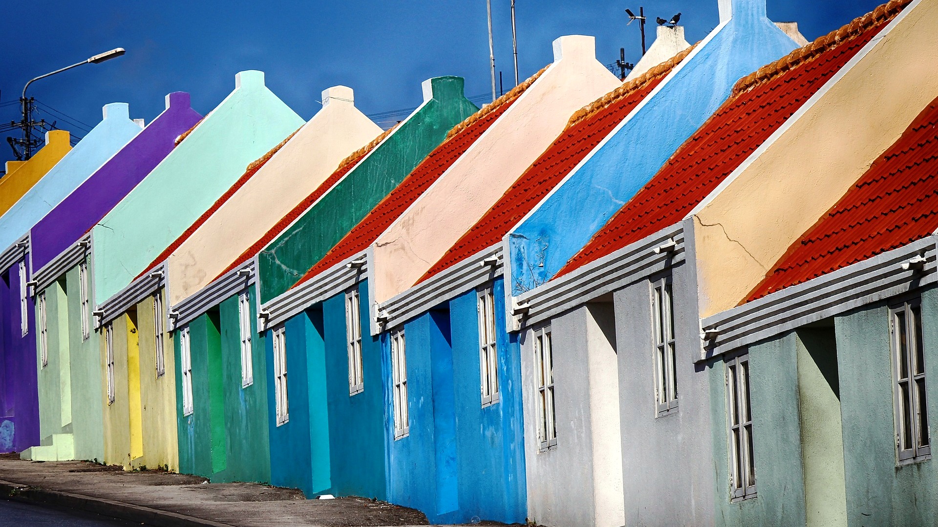 Reihe farbenfroher Häuser mit roten Ziegeldächern auf Curaçao